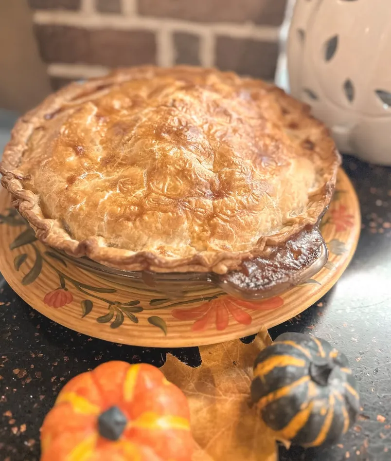 A whole apple pie with a golden lattice top