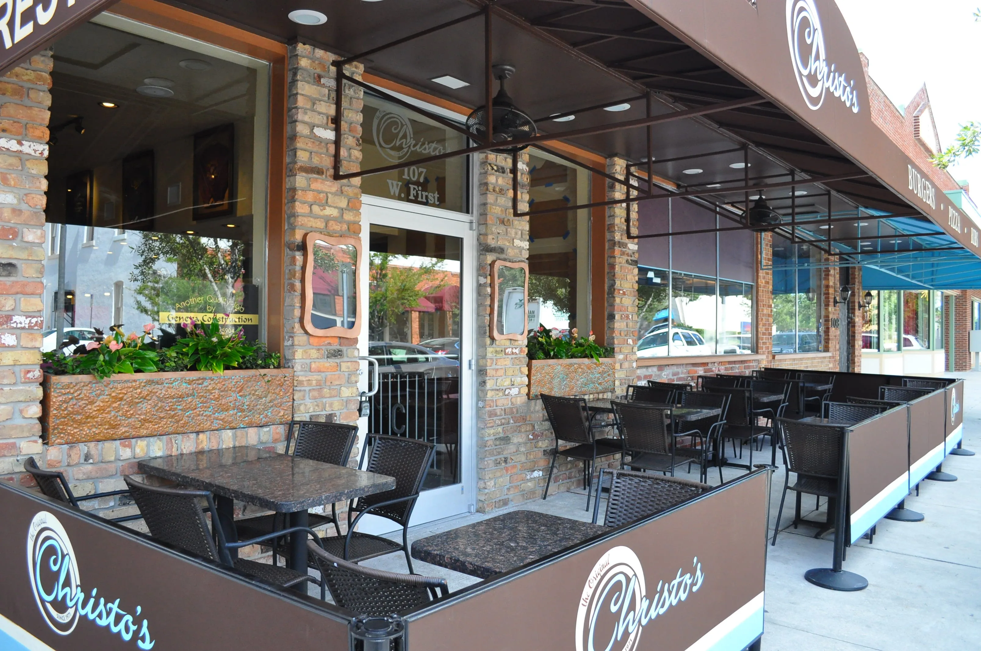 The patio out front of Christo's on First Street, tables under the branded awnings